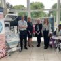 Members of the HRC DDR team attending the UHB Research Showcase standing by their exhibition stand which contains banner stands and some medical equipment and a dummy patient in a wheelchair